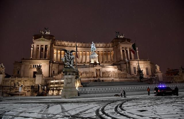 People walk in the snow past Venezia square in Rome. (AFP Photo) People walk in the snow past Venezia square in Rome. (AFP Photo)