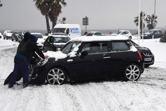 People push a vehicle on a snow covered road, on February 28, 2018, in Palavas-les-Flots, southern France, after heavy snow fall. (AFP) People push a vehicle on a snow covered road, on February 28, 2018, in Palavas-les-Flots, southern France, after heavy snow fall. (AFP)