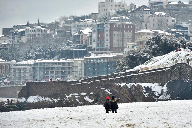 People walk on the beach covered with snow in San Sebastian, northern Spain. (AFP) People walk on the beach covered with snow in San Sebastian, northern Spain. (AFP)