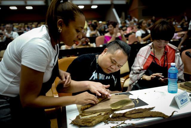 A Cuban instructor (L) helps participants roll cigars during a master class. (AFP) A Cuban instructor (L) helps participants roll cigars during a master class. (AFP)