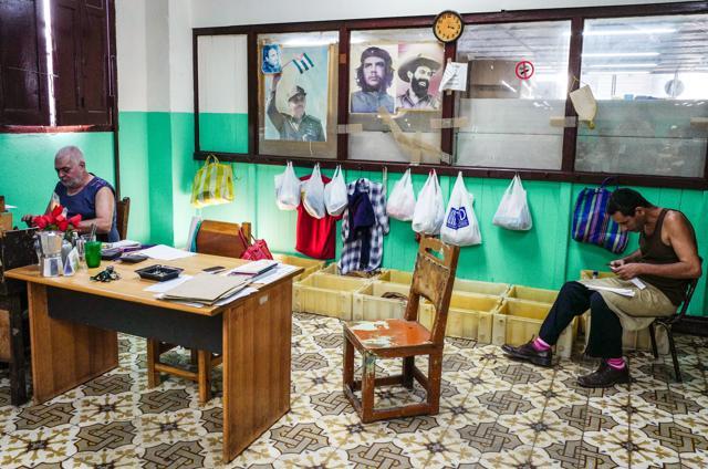 Workers of the H Upmann Cigar factory work next to porters of Cuban late leaders and Cuban President Raul Castro in Havana. (AFP) Workers of the H Upmann Cigar factory work next to porters of Cuban late leaders and Cuban President Raul Castro in Havana. (AFP)