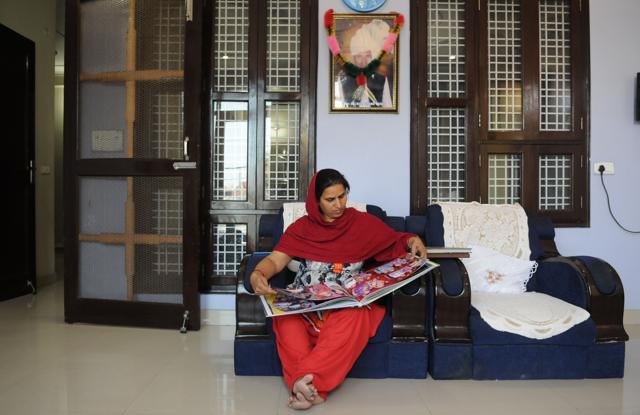 Akash Yadav’s mother Kamlesh shows pictures of his son, in Gurgaon. (Parveen Kumar/HT Photo)