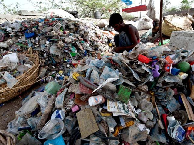 A rag-picker sorts through plastic bottles and polythene bags near a garbage land fill on World Environment Day in New Delhi. AFP/Prakash Singh