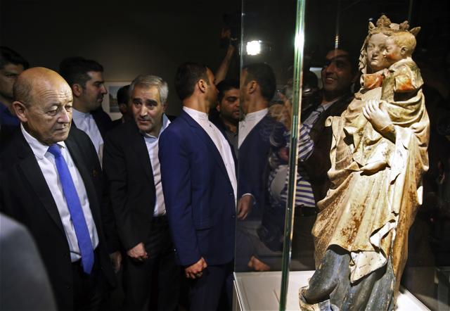 French Foreign Minister Jean-Yves Le Drian, left, looks at a statue titled, The Virgin and Child. (AP)