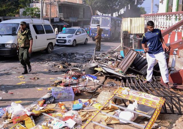 Sri Lankan police commandos patrol next to a damaged shop in the central district of Kandy on March 6, 2018, after a state of emergency was declared. (AFP photo) Sri Lankan police commandos patrol next to a damaged shop in the central district of Kandy on March 6, 2018, after a state of emergency was declared. (AFP photo)