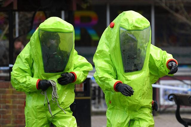 Members of the emergency services in green biohazard suits work to affix the tent over the bench where the former Russian spy and his daughter were found on March 4 in critical condition at The Maltings shopping centre in Salisbury, England, on March 8, 2018. (AFP)