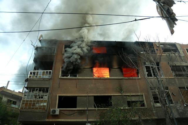 Fire flames rip through a building following Syrian government bombardment in the town of Douma. (AFP Photo) Fire flames rip through a building following Syrian government bombardment in the town of Douma. (AFP Photo)