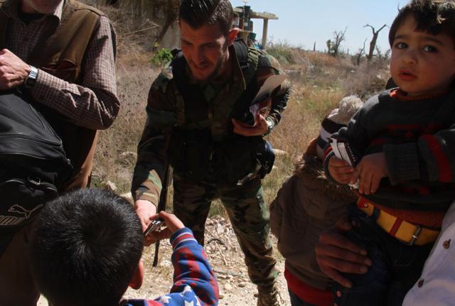A Syrian government soldier gives sweets to evacuated civilians from the rebel-held Eastern Ghouta on Wednesday. (AFP Photo) A Syrian government soldier gives sweets to evacuated civilians from the rebel-held Eastern Ghouta on Wednesday. (AFP Photo)