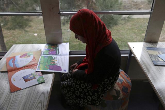 Qaderia, 10, reads a book inside the bus library. (AP Photo/Rahmat Gul) Qaderia, 10, reads a book inside the bus library. (AP Photo/Rahmat Gul)