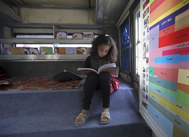 Zainab, 9, reads inside the bus library. (AP Photo/Rahmat Gul) Zainab, 9, reads inside the bus library. (AP Photo/Rahmat Gul)
