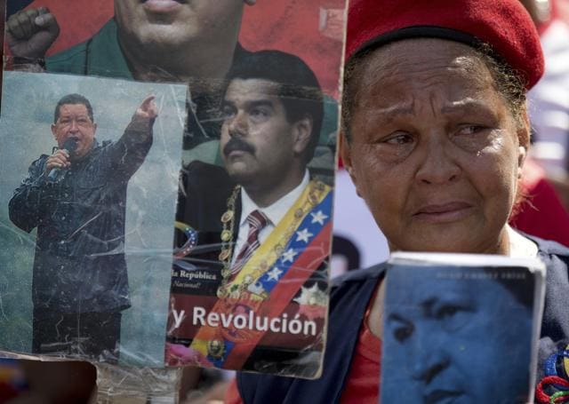 Aa supporter of the late Venezuelan President Hugo Chavez cries as she holds pictures of Chavez and Venezuela's President Nicolas Maduro during a rally. (AP) Aa supporter of the late Venezuelan President Hugo Chavez cries as she holds pictures of Chavez and Venezuela's President Nicolas Maduro during a rally. (AP)