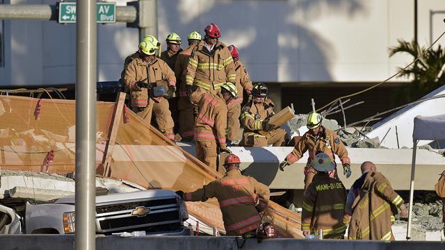 Miami-Dade Fire Rescue firefighters work on a brand new, 950-ton pedestrian bridge that collapsed in front of Florida International University on Thursday in Miami. (AP ) Miami-Dade Fire Rescue firefighters work on a brand new, 950-ton pedestrian bridge that collapsed in front of Florida International University on Thursday in Miami. (AP )