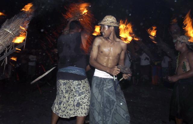 Balinese men walk under flaming coconut leaves at Pundukdawa village during cleansing procession from evil spirit called "Mebubu" before Nyepi, the annual day of silence marking Balinese Hindu new year in Bali. (AP Photo) Balinese men walk under flaming coconut leaves at Pundukdawa village during cleansing procession from evil spirit called "Mebubu" before Nyepi, the annual day of silence marking Balinese Hindu new year in Bali. (AP Photo)