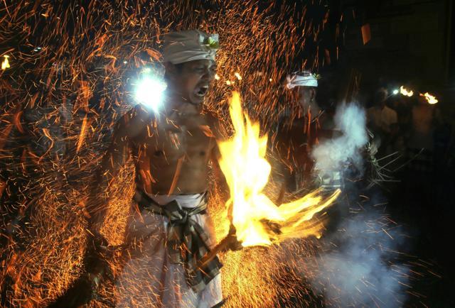 A Balinese man is hit with flaming coconut leaves during the fire fight ritual called 'Lukat Gni' before Nyepi, the annual day of silence marking Balinese Hindu new year in Klungkung, Bali. (AP Photo) A Balinese man is hit with flaming coconut leaves during the fire fight ritual called 'Lukat Gni' before Nyepi, the annual day of silence marking Balinese Hindu new year in Klungkung, Bali. (AP Photo)