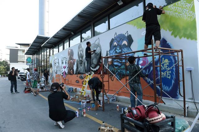 Graffiti artists spraypainting a mural. (AFP) Graffiti artists spraypainting a mural. (AFP)