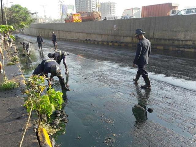 Fire department officials working to clear the oil spill. (Praful Gangurde) Fire department officials working to clear the oil spill. (Praful Gangurde)