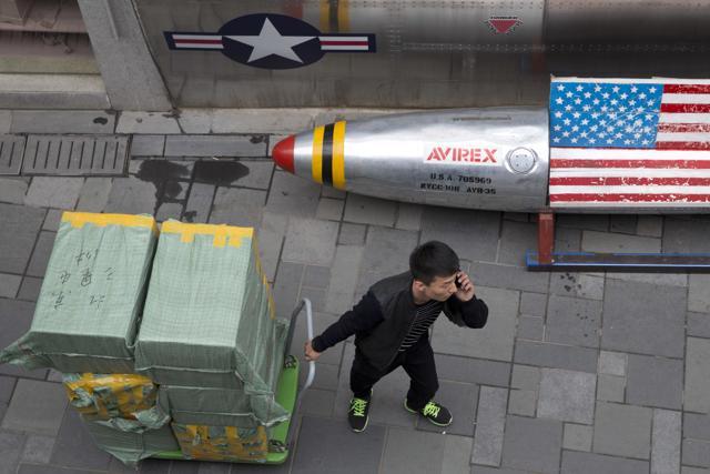 A delivery man calls for directions while pulling a cart of goods past a US apparel store in Beijing. (AP File Photo) A delivery man calls for directions while pulling a cart of goods past a US apparel store in Beijing. (AP File Photo)
