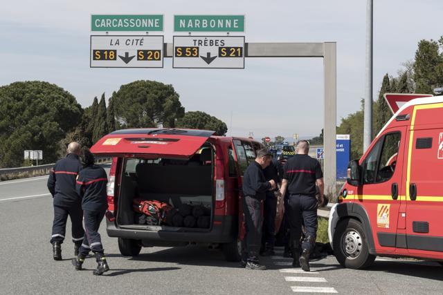 French police and firefighters secure the entrance of Trebes, southern France, where an armed man took hostages in a supermarket, on Friday. (AP) French police and firefighters secure the entrance of Trebes, southern France, where an armed man took hostages in a supermarket, on Friday. (AP)