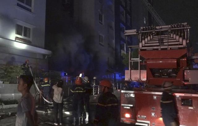 Firefighters use lights to look for people trapped in a condominium complex during a fire in Ho Chi Minh City, Vietnam. (AP) Firefighters use lights to look for people trapped in a condominium complex during a fire in Ho Chi Minh City, Vietnam. (AP)