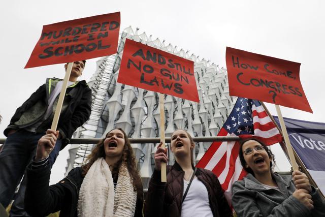 Protestors carry placards and shout slogans during a demonstration calling for greater gun control, outside the US Embassy in south London. (AFP) Protestors carry placards and shout slogans during a demonstration calling for greater gun control, outside the US Embassy in south London. (AFP)