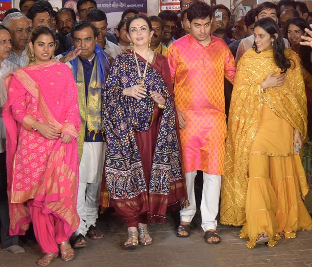 Mukesh Ambani (2L) and his wife Nita Ambani (C) along with their children Isha Ambani (L), Akash Ambani (3R), Anant Ambani (R) and Akash's fiancée Shloka Mehta (2R) posing for a photograph after seeking blessings at the Siddhivinayak temple in Mumbai. (AFP) Mukesh Ambani (2L) and his wife Nita Ambani (C) along with their children Isha Ambani (L), Akash Ambani (3R), Anant Ambani (R) and Akash's fiancée Shloka Mehta (2R) posing for a photograph after seeking blessings at the Siddhivinayak temple in Mumbai. (AFP)