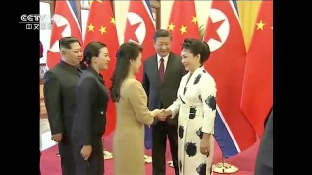 Ri Sol Ju, wife of North Korean leader Kim Jong Un, shakes hands with Peng Liyuan, wife of Chinese President Xi Jinping as the two leaders watch, in this still image taken from video released on March 28, 2018. (REUTERS) Ri Sol Ju, wife of North Korean leader Kim Jong Un, shakes hands with Peng Liyuan, wife of Chinese President Xi Jinping as the two leaders watch, in this still image taken from video released on March 28, 2018. (REUTERS)