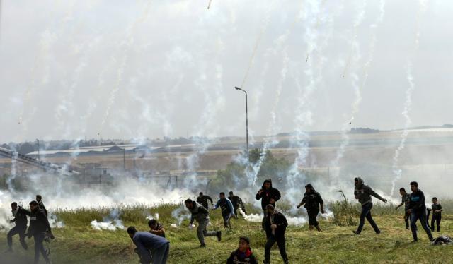 Palestinians fleeing as tear gas grenades begin to drop during a demonstration near the border with Israel east of Gaza City to commemorate Land Day. (AFP) Palestinians fleeing as tear gas grenades begin to drop during a demonstration near the border with Israel east of Gaza City to commemorate Land Day. (AFP)