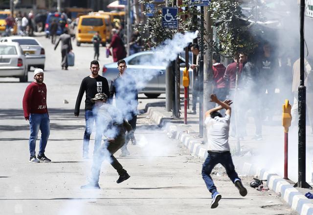 Palestinian demonstrators run for cover during clashes with Israeli forces in occupied West Bank city of Hebron as a general strike is called for by local leaders in solidarity with Gaza. (AFP) Palestinian demonstrators run for cover during clashes with Israeli forces in occupied West Bank city of Hebron as a general strike is called for by local leaders in solidarity with Gaza. (AFP)
