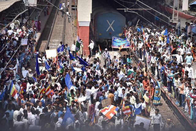 Hundreds of protesters block the railway track during 'Bharat Bandh' call by Dalit organisations against the alleged 'dilution' of Scheduled Castes/Scheduled Tribes act, in Aligarh on Monday. (PTI) Hundreds of protesters block the railway track during 'Bharat Bandh' call by Dalit organisations against the alleged 'dilution' of Scheduled Castes/Scheduled Tribes act, in Aligarh on Monday. (PTI)