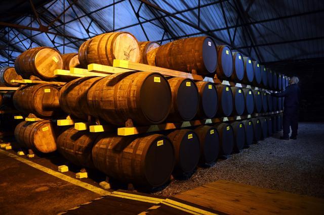 Emplyee Nigel Baker works in one of the distillery warehouses where the oak barrels of whisky can be stored for up to 25 years before bottling, at the Auchentoshan Distillery near Glasgow, Scotland. (AFP PHOTO / ANDY BUCHANAN) Emplyee Nigel Baker works in one of the distillery warehouses where the oak barrels of whisky can be stored for up to 25 years before bottling, at the Auchentoshan Distillery near Glasgow, Scotland. (AFP PHOTO / ANDY BUCHANAN)