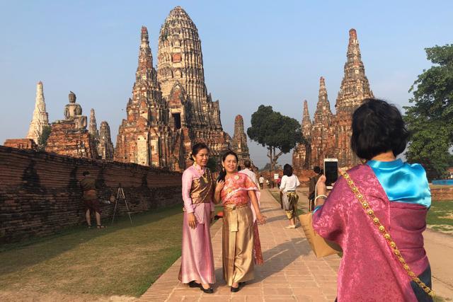 Women dressed in traditional costumes pose for a picture. (REUTERS)