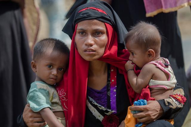 A Rohingya Muslim woman holds her kids after the Bangladeshi government moved them to newly allocated refugee camp areas. (AP/File)