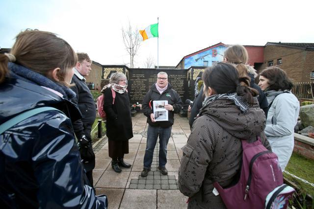 Coiste guide Peadar Whelan (C) talks to tourists as he guides them in a memorial garden to IRA volunteers during a political guided tour in west Belfast. (AFP) Coiste guide Peadar Whelan (C) talks to tourists as he guides them in a memorial garden to IRA volunteers during a political guided tour in west Belfast. (AFP)