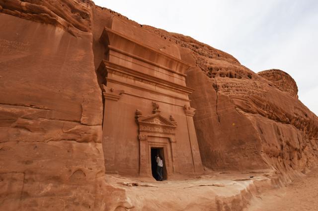 A picture taken on March 31, 2018 shows a journalist taking a photo of a tomb at Madain Saleh, a UNESCO World Heritage site, near Saudi Arabia's northwestern town of Al-Ula. (AFP)