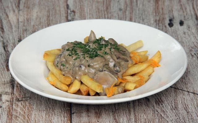 The wild mushroom poutine, was just fries, grated cheese and a pile of mushrooms in a cream sauce that overwhelms the dish. (Bhushan Koyande / HT Photo)