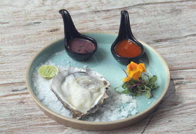 The single steamed oyster, ready for a drizzle of spicy-sweet smoked butter sauce, balsamic-wine-soy-shallot dressing and lime juice, is a must-try. (Bhushan Koyande / HT Photo)