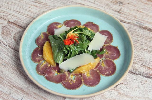 The mustard-flecked duck carpaccio is a plate of complementary contrasts, with shaved shards of Pondicherry parmesan poised on a bouncy pile of arugula, orange segments and capers. (Bhushan Koyande / HT Photo)