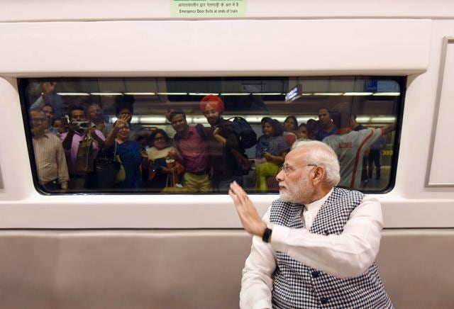 People take photographs and wave at Prime Minister Narendra Modi from the station platform. The DMRC said metro services were unaffected by Modi’s travel. (PIB) People take photographs and wave at Prime Minister Narendra Modi from the station platform. The DMRC said metro services were unaffected by Modi’s travel. (PIB)