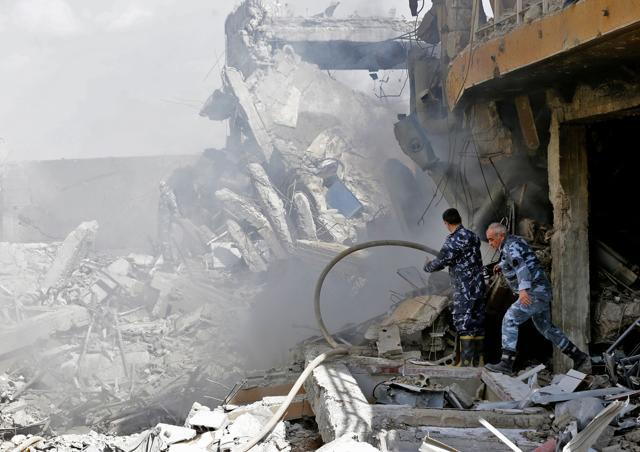 Syrian soldiers inspect the wreckage of a building described as part of the Scientific Studies and Research Centre (SSRC) compound in the Barzeh district, north of Damascus,. (AFP)
