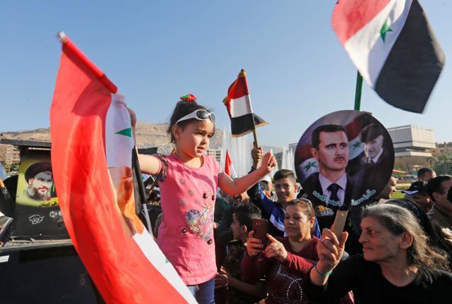 Syrians wave the national flag and portraits of President Bashar al-Assad as they gather at the Umayyad Square in Damascus on April 14, 2018 (AFP) Syrians wave the national flag and portraits of President Bashar al-Assad as they gather at the Umayyad Square in Damascus on April 14, 2018 (AFP)