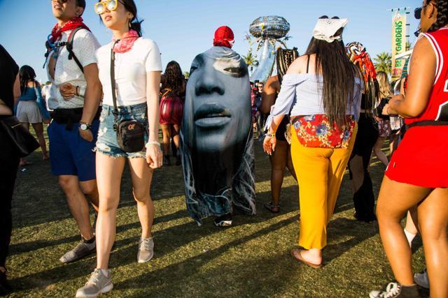 A fan walks through the festival grounds drapped in a Beyonce blanket during the Coachella Music and Arts Festival. (AFP)