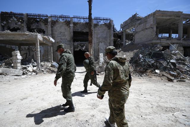 Russian military police officers check a weapons factory left behind by members of the Army of Islam group, in the town of Douma, the site of a suspected chemical weapons attack, near Damascus. (AP) Russian military police officers check a weapons factory left behind by members of the Army of Islam group, in the town of Douma, the site of a suspected chemical weapons attack, near Damascus. (AP)