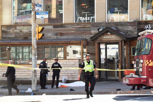 Police secure an area around a covered body in Toronto after a van mounted a sidewalk, crashing into a number of pedestrians on Monday. (AP) Police secure an area around a covered body in Toronto after a van mounted a sidewalk, crashing into a number of pedestrians on Monday. (AP)