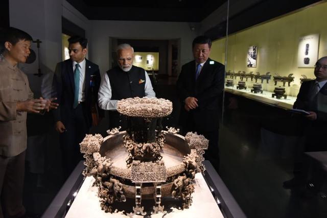 PM Modi and President Xi look at an artefact on display at the Hubei Provincial Museum in Wuhan on Saturday. Modi on Twitter thanked President Xi Jinping for the “wonderful gesture of personally accompanying” him. “The Museum is home to great facets of Chinese history and culture,” he said of his visit. (Narendra Modi/Twitter)