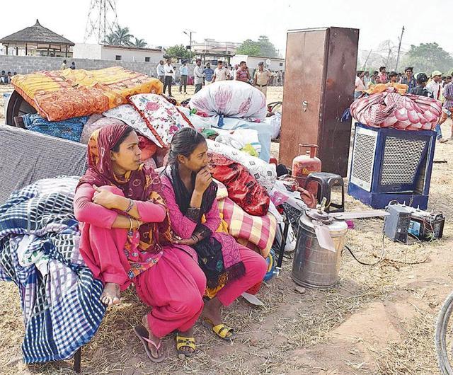 Residents left roofless during the drive sitting with their belongings. Two women fainted and were rushed to hospital. (Sikander Singh Chopra/HT) Residents left roofless during the drive sitting with their belongings. Two women fainted and were rushed to hospital. (Sikander Singh Chopra/HT)