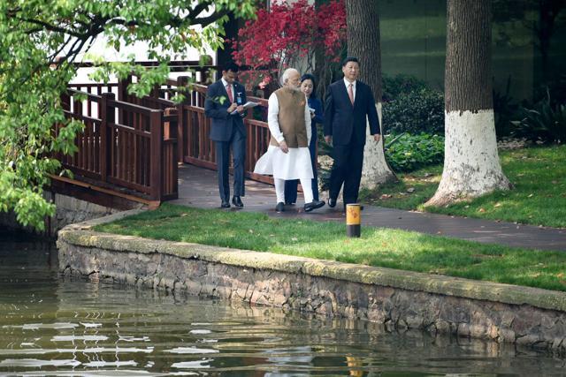 The informal talks between Modi and Xi were restricted to just the two leaders and their interpreters, seen walking behind them. R Madhu Sudan, the first secretary (political) at the Indian embassy in Beijing was Modi’s interpreter. (Reuters)