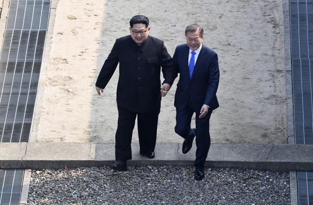 North Korean leader Kim Jong Un, left, and South Korean President Moon Jae-in cross the military demarcation line to the South side at the border village of Panmunjom in the Demilitarized Zone Friday, April 27, 2018. (AP) North Korean leader Kim Jong Un, left, and South Korean President Moon Jae-in cross the military demarcation line to the South side at the border village of Panmunjom in the Demilitarized Zone Friday, April 27, 2018. (AP)
