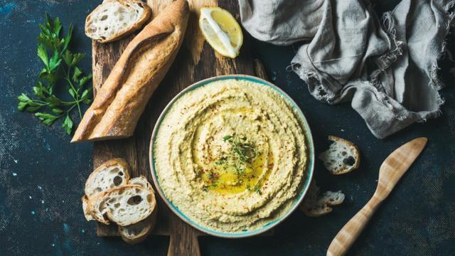 For cravings on the go, opt for hummus with wholegrain crackers. (Istock)