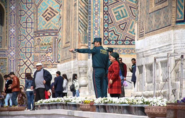 Members of a newly-formed Tourist Police helping a woman in the famed silk road city of Samarkand. (AFP) Members of a newly-formed Tourist Police helping a woman in the famed silk road city of Samarkand. (AFP)