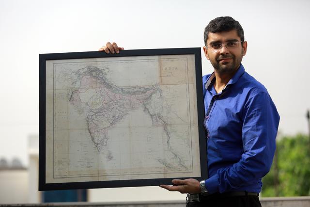 Anshul Kaushik poses with a rare map of unpartitioned India, which is part of his collection. (Amal KS/HT Photo)